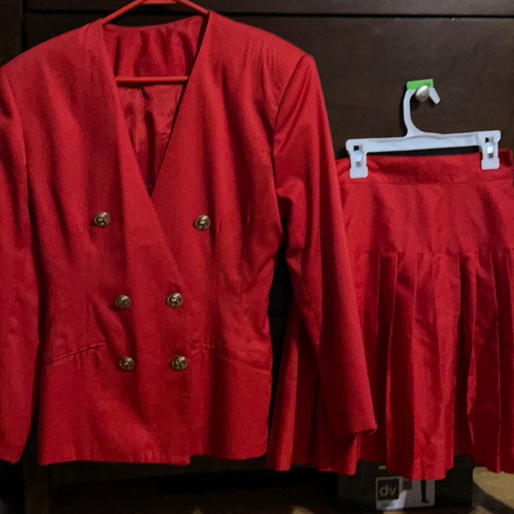 Double breasted red jacket and pleated skirt